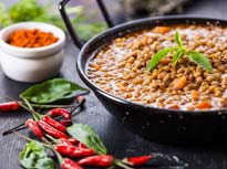 Thumbnail of a decorated bowl of lentils and red chili peppers on a table