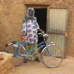 Azeta poses with the bike she was able to purchase thanks to her niébé sales. Copyright: WFP
